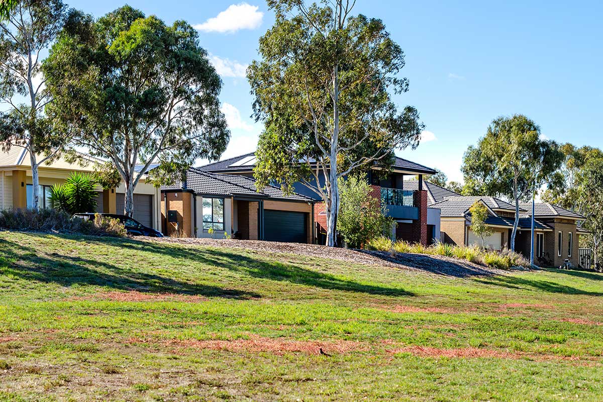Homes on a suburban street with established trees and landscaped front yards.